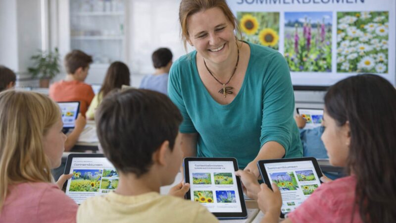 Schulklasse arbeitet digital zum Thema Sommerblumen mit Tablets